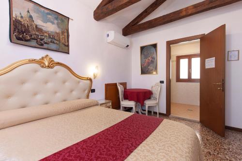 1 dormitorio con 1 cama, mesa y sillas en Alloggi SS Giovanni e Paolo, en Venecia