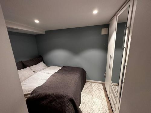 - une petite chambre avec un lit et un miroir dans l'établissement Basement apartment with parking, à Ålesund