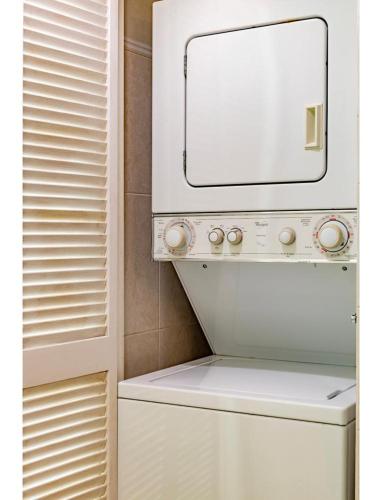 a washing machine with a mirror on top of it at Two Bedroom Oceanview Apartment in Brickell in Miami