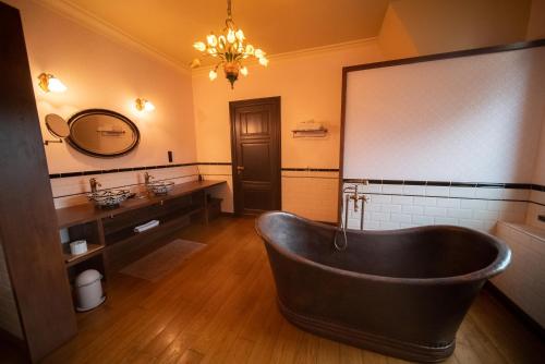 a bathroom with a bath tub and a mirror at Clementine in Kruishoutem