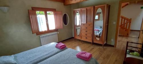 een slaapkamer met een bed, een dressoir en een spiegel bij LA TORRE DE CUBILLAS in Matienzo