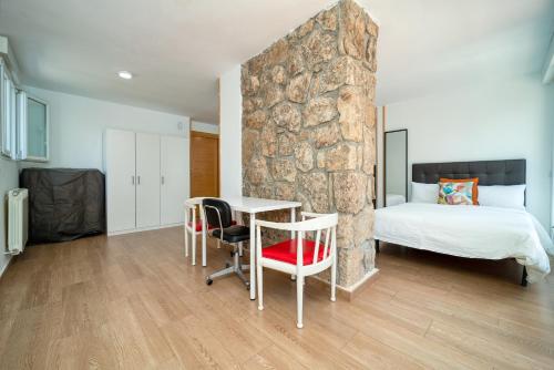 a bedroom with a bed and a table and chairs at A CASACAFÉ Madrid Pozuelo Estación Private Rooms in Pozuelo de Alarcón