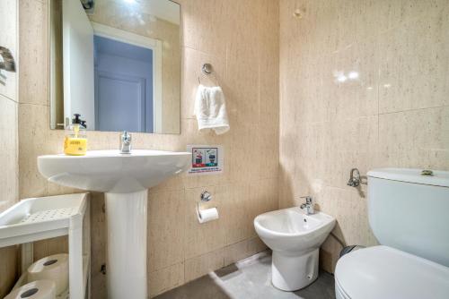 a bathroom with a sink and a toilet and a mirror at A CASACAFÉ Madrid Pozuelo Estación Private Rooms in Pozuelo de Alarcón