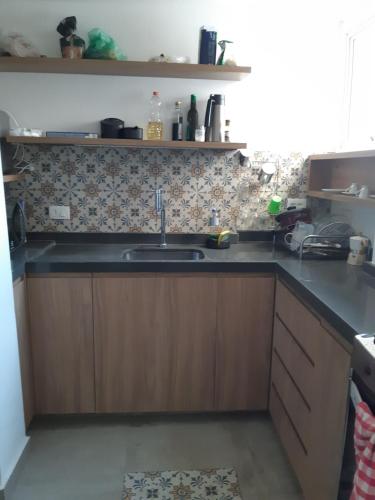 una cocina con fregadero y armarios de madera en Varanda_77 - Cely Ades, en São Paulo