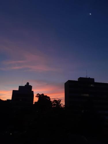 uma silhueta de um horizonte da cidade ao pôr do sol em Varanda_77 - Cely Ades em São Paulo