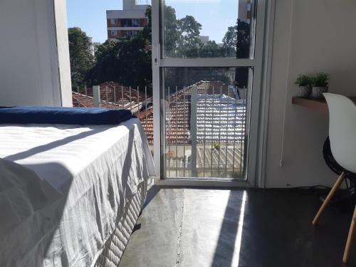 a bedroom with a bed and a window with a view at Varanda_77 - Cely Ades in Sao Paulo