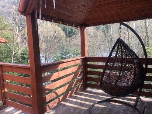 a swing on the porch of a cabin at Villa Затишна de luxe in Mykulychyn