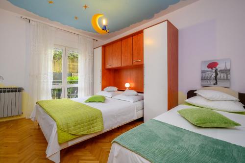 a bedroom with two beds and a window at Apartments Jurić in Podstrana