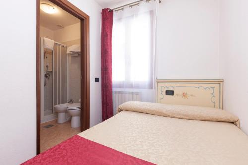 a bedroom with a bed and a bathroom with a toilet at Alloggi SS Giovanni e Paolo in Venice