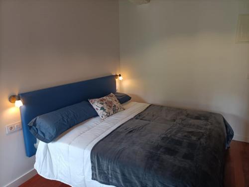 a bed with a blue headboard in a bedroom at LA GALLEGA in Valdoviño