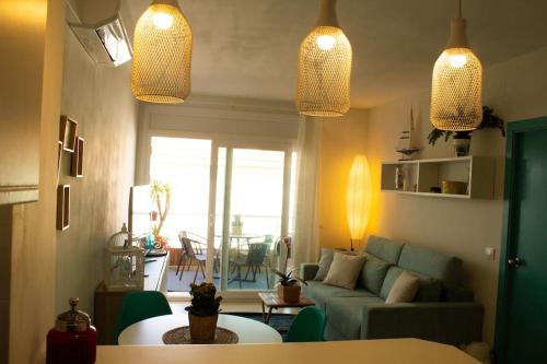 een woonkamer met een bank en een tafel bij Alegre apto con piscina, a 300m de la playa. in Blanes