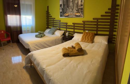1 dormitorio con 2 camas y toallas. en Casa Rural La Chistera en Avila