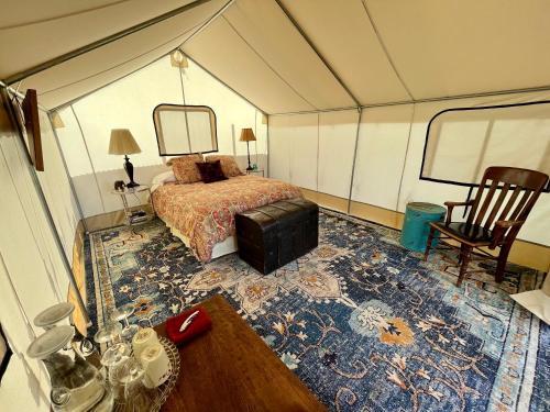Paonia的住宿－Zinnia Glamping Tent at Zenzen Gardens，帐篷内带一张床和一张桌子的房间