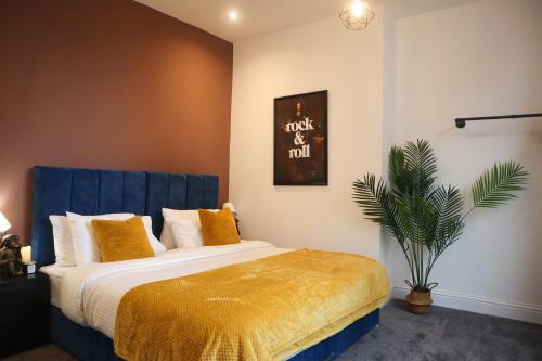 een slaapkamer met een bed met een blauw hoofdeinde en een plant bij Berry's Retreat - Kist Accommodates in Knaresborough