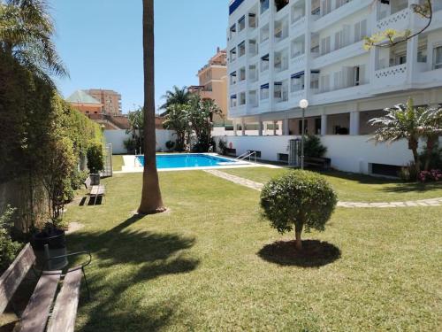 un patio con un edificio y una piscina en Apartamento tranquilidad, playa,wifi, en Torremolinos