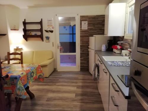 - une cuisine avec une table et un canapé dans une chambre dans l'établissement Appartement classé 3 étoiles au 1er étage d'une maison avec jardin dans un quartier calme, à Cavalaire-sur-Mer