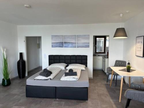 a bedroom with a large bed and a dining room at TTP 16 Friedrichshafen in Friedrichshafen