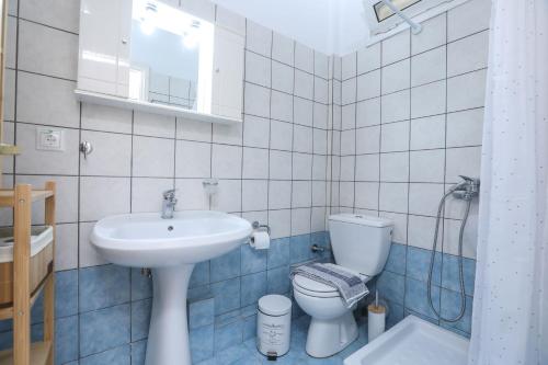 een badkamer met een wastafel en een toilet bij Marilia’s apartment in Kanálion