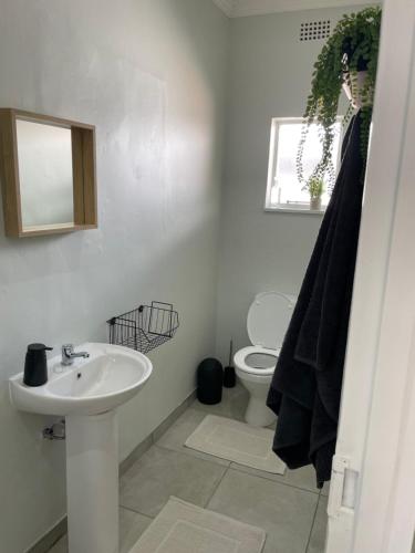 a white bathroom with a sink and a toilet at 10 Paul Roos in Kimberley