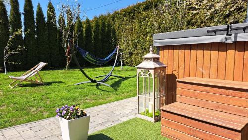 a garden with a hammock and a fence with a cage at Apartamenty Bujaki Ustroń in Ustroń