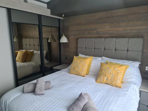 een slaapkamer met een groot wit bed met gele kussens bij Mawgan Pads Perranporth in Cubert