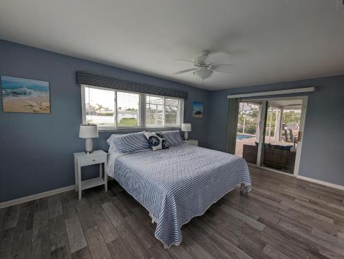 Schlafzimmer mit einem Bett und einem Deckenventilator in der Unterkunft Blue Flamingo - Pool, Sunsets, Dock, Lift, Direct Gulf Access! in Cape Coral
