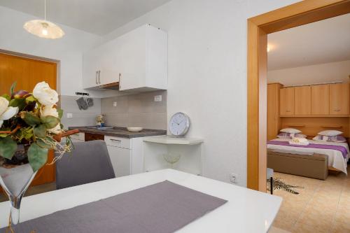 a kitchen with a table and a room with a bed at Apartments Jurić in Podstrana