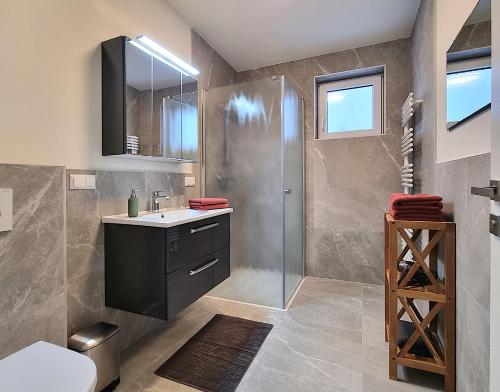 La salle de bains est pourvue d'un lavabo et d'une douche. dans l'établissement Ferienhaus DAS GLAB, à Velden am Wörther See
