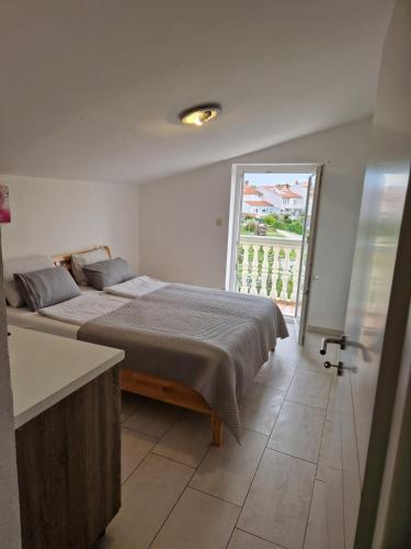 a bedroom with a bed and a large window at Apartment Vilic in Pula