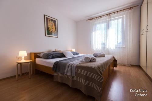 een slaapkamer met een bed en een raam bij House Silvia in Grižane