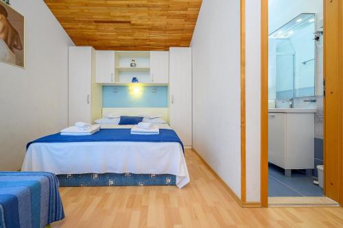 a small bedroom with a bed and a bathroom at Apartments Jurić in Podstrana