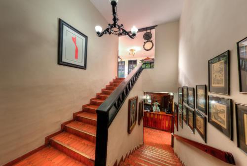 a staircase in a home with paintings on the walls at Hotel Camino Real Popayán Colombia in Popayan