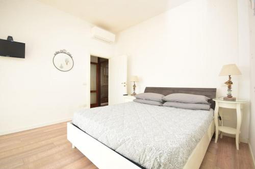 a white bedroom with a bed and a desk at Appartamento Sul Mare - Bellaria in Bellaria-Igea Marina