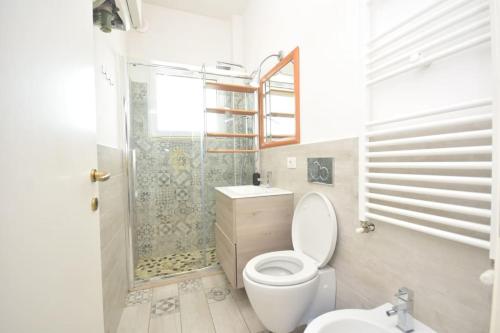 uma casa de banho com um WC, um chuveiro e um lavatório. em Appartamento Sul Mare - Bellaria em Bellaria-Igea Marina