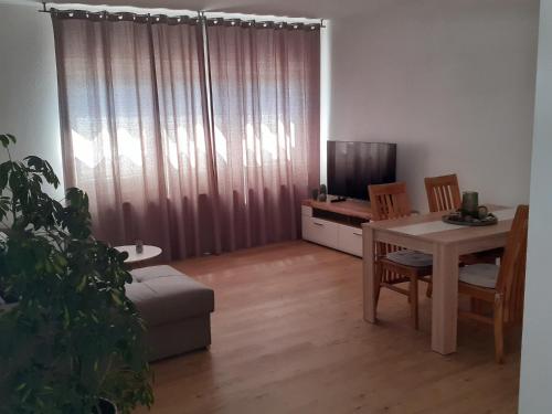 een woonkamer met een tafel en een televisie bij Ferienhaus Wehretal 