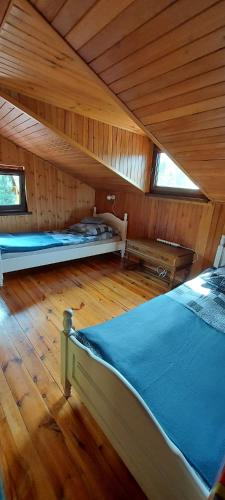 a room with two beds in a wooden cabin at Zacisze in Uście