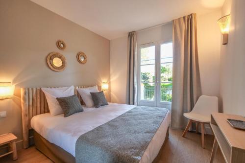 une chambre avec un lit, un bureau et une fenêtre dans l'établissement Paradis Bleu Saint Tropez - 24, à Saint-Tropez