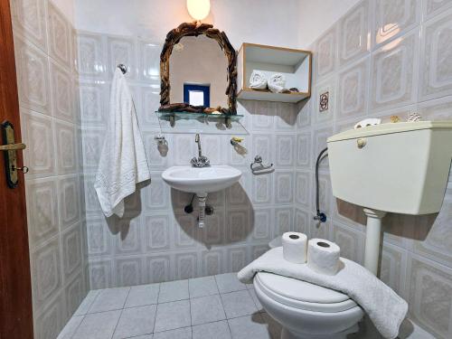 a bathroom with a toilet and a sink and a mirror at Pavlis Studios in Marathokampos