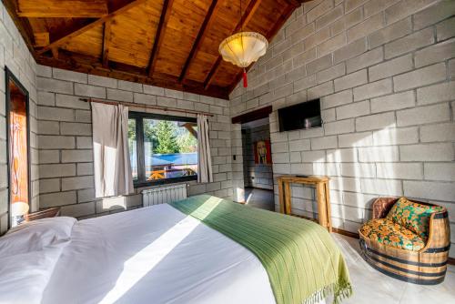 a bedroom with a bed and a chair in a room at Arcano Casa Montaña in Villa La Angostura
