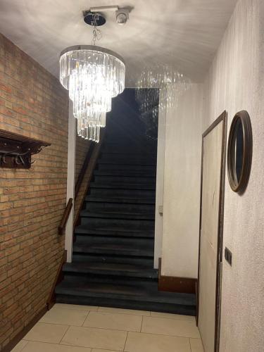 a hallway with a staircase with a chandelier at Private room in the centre of Tilburg in Tilburg