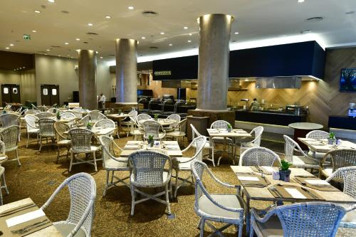 a dining room with tables and chairs and a restaurant at Hotel Atlante Plaza in Recife