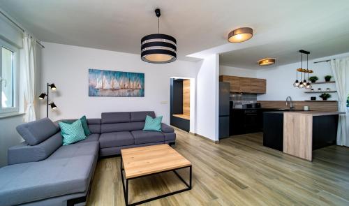 a living room with a blue couch and a kitchen at Villa Calma in Rab