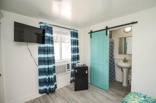 a bathroom with a television and a sink at Driftwood Villas at Anna Maria Island Inn in Holmes Beach