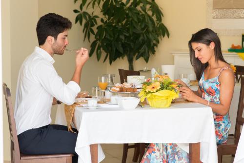 a man and woman sitting at a table eating food at Villa Marchesa in Castelnuovo Cilento