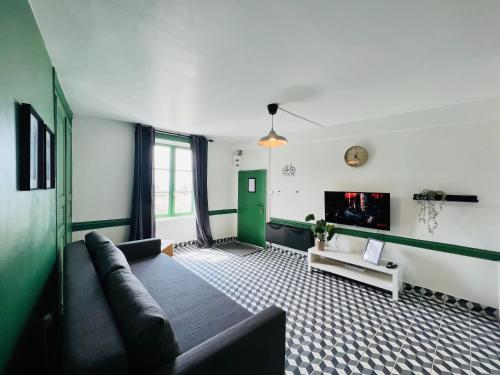een woonkamer met een bank en een tv bij DnN - Retro 1BR, center Thiers - free wifi and parking - near Vichy, Clermont, Lyon in Thiers