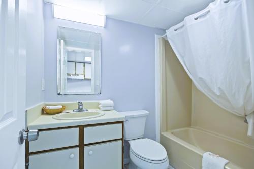 a bathroom with a sink and a toilet and a tub at South Seas Ocean Front in Myrtle Beach