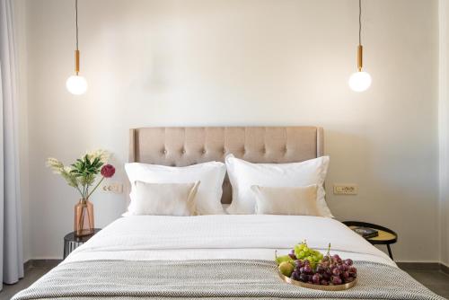 a bedroom with a bed with a bowl of fruit on it at Meliora Suites in Drapaniás