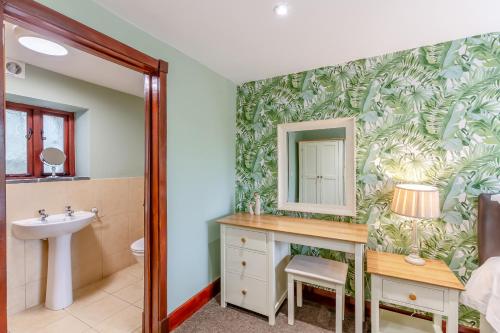 La salle de bains est pourvue d'un lavabo et d'un miroir. dans l'établissement Hill Side Barn, à Ireleth