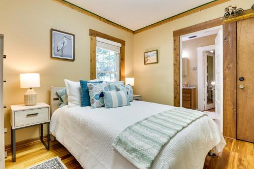 1 dormitorio con 1 cama grande con almohadas azules en Lakefront Tavares Cabin with Deck, Patio and Dock! en Tavares