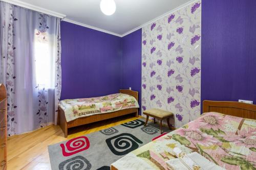 1 Schlafzimmer mit 2 Betten und einer lila Wand in der Unterkunft Bokneti - Guest House, Agro Tourism Destination in Kʼareli